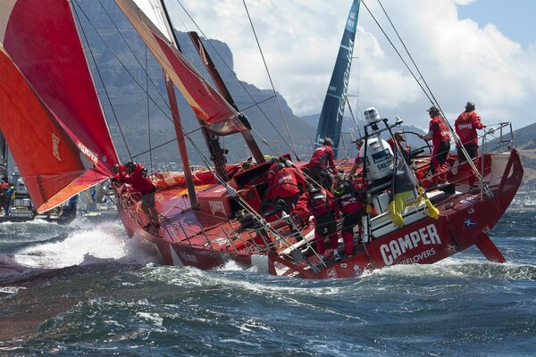 Les gens sur un yacht de couleur rouge au milieu de l océan