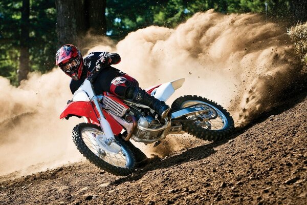 Dust from under the wheels of a bike on a steep turn