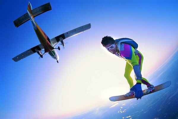 Atleta volando en el cielo bajo un avión