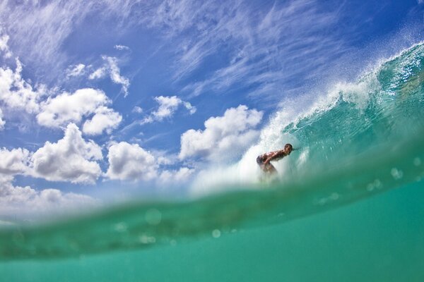 Surfing st on a beryuzova wave under blue skies