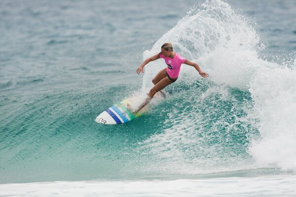 On a small wave, a girl is surfing