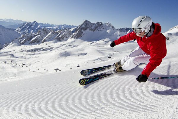 Montañas de cielo azul, monta una mujer en los esquís