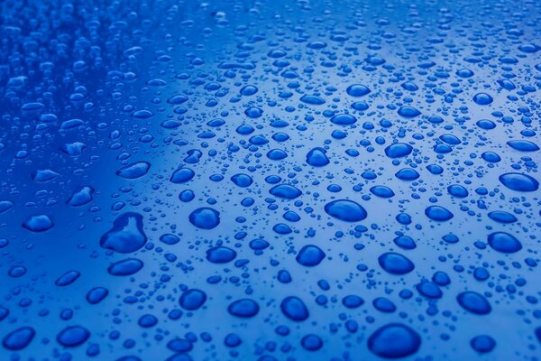 Macro shooting of water droplets on the hood of the car