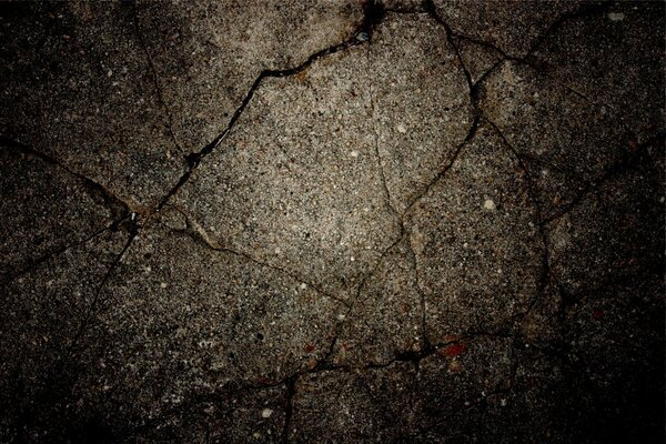Cracks on the dark asphalt near