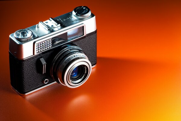 Fotocamera classica su sfondo arancione