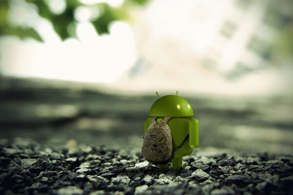 Macro picture of a green man with a backpack on pebbles