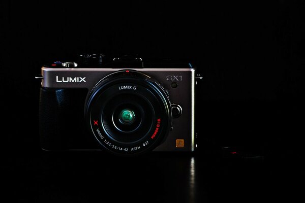 The lumix camera is dark , on a dark background