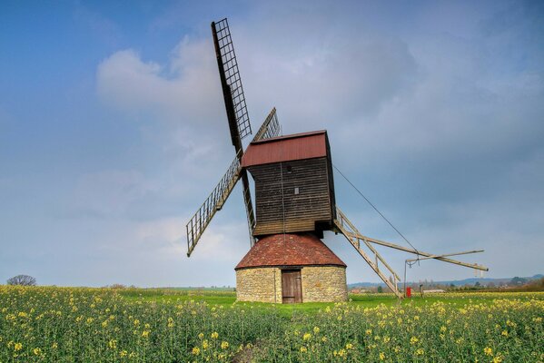 An old mill in a field against a blue sky