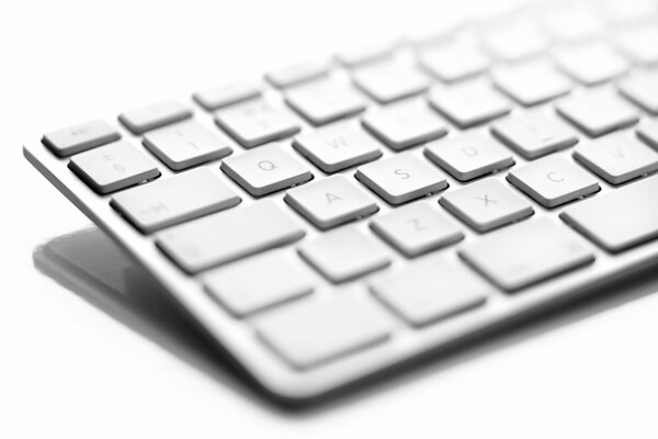 Half of a white keyboard on a white background