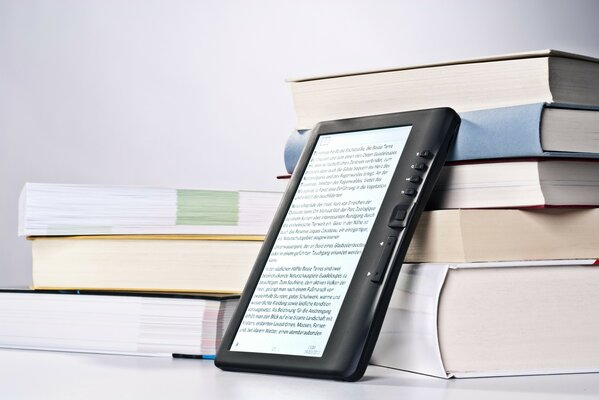 Tablet mit Ständer in Form von alten Büchern auf grauem Hintergrund