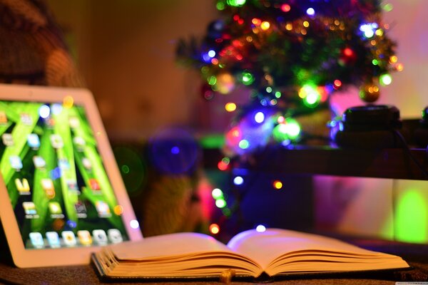 An open book next to a tablet at Christmas