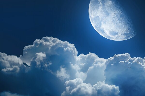 Luna brillante en el cielo nocturno en nubes esponjosas