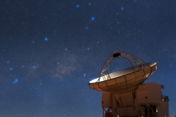 Radiotélescope sur fond de constellations dans le ciel nocturne