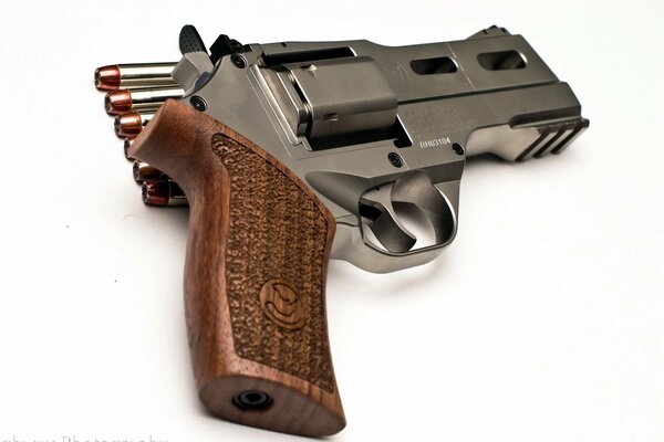 Un revolver avec des cartouches est représenté sur un fond blanc