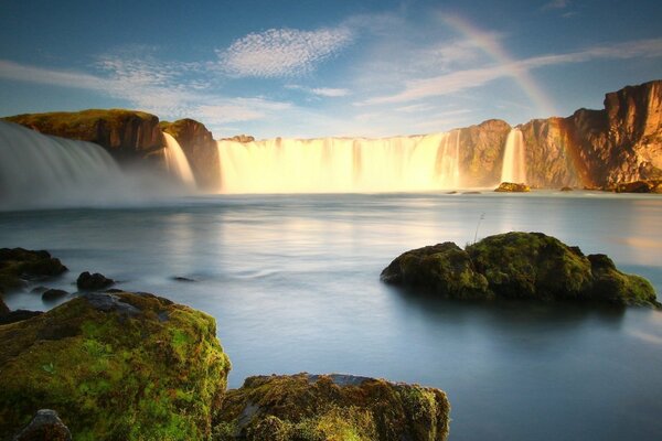 Arco iris con fondo de cascada y musgo