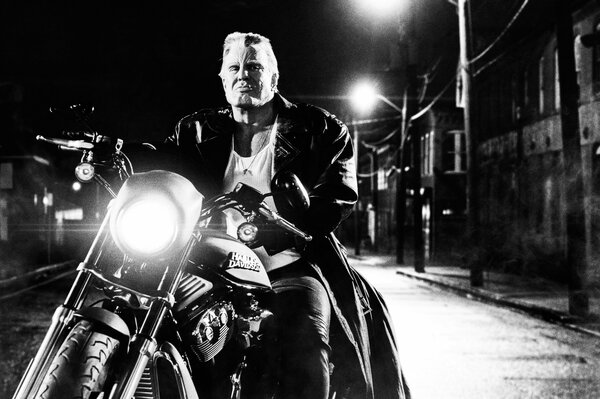 Mickey Rourke auf einem Motorrad in schwarz und weiß