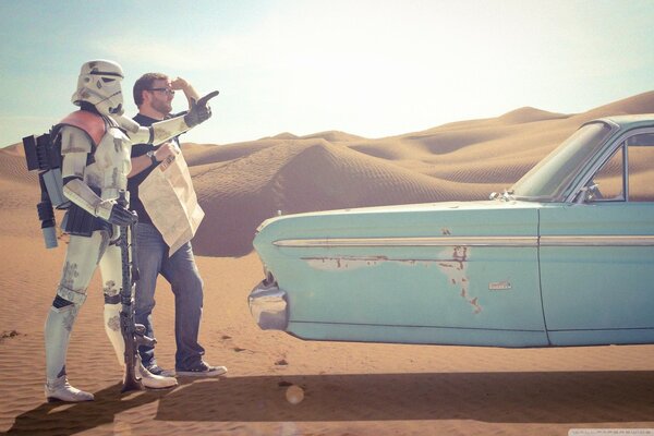 Two people in the desert and a car