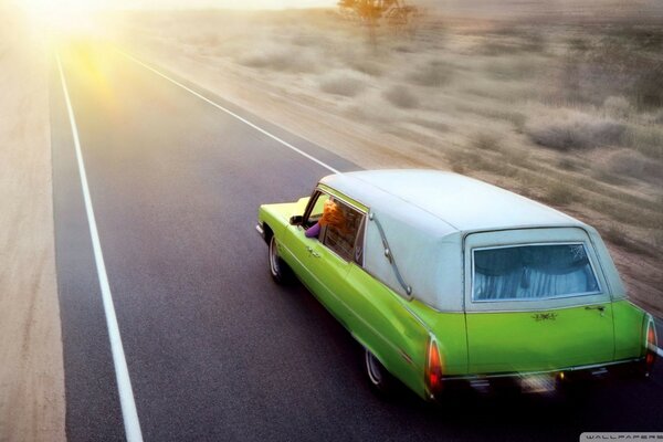 Green retro car rides on the road