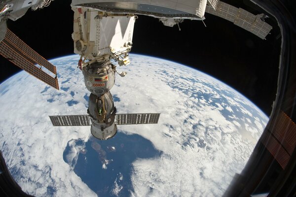 Vista desde el eluminador de la estación a la tierra, un desfile de planetas en el espacio negro