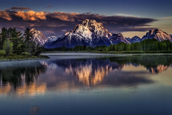 Snowy mountains. Lake. The clouds