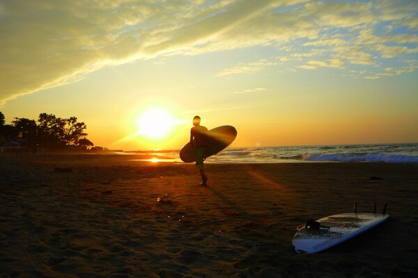 Ragazzo in sella a una tavola da surf all alba