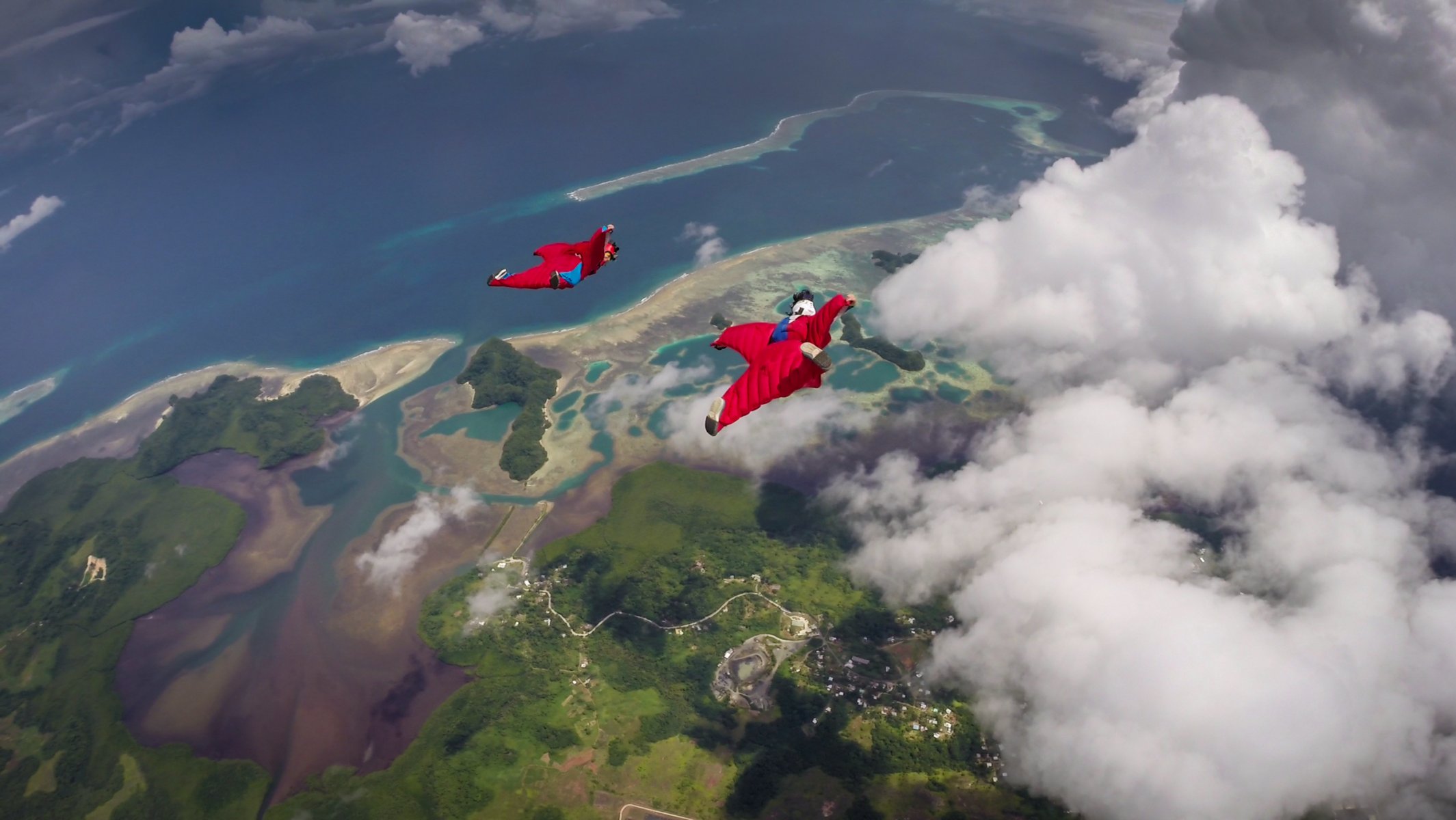 traje de alas pilotos educación fs casco cámaras nubes sombras mar isla contenedor paracaídas deportes extremos