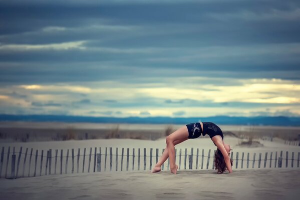 Gymnast girl on the sand