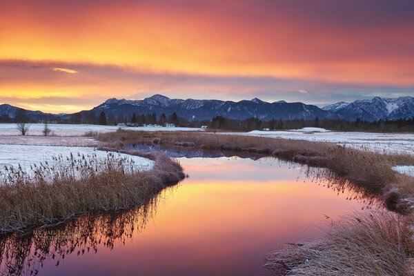 Bright orange winter sunset in a mountain forest