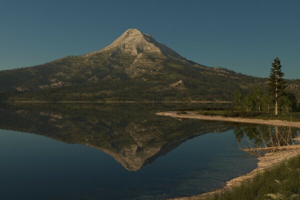 Las montañas se reflejan en el agua clara