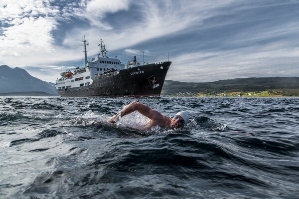 Against the background of a sea vessel swimmer