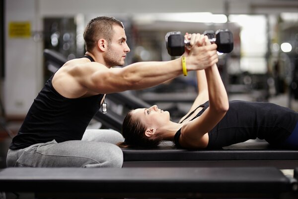 Entraînement avec un entraîneur personnel dans la salle de gym