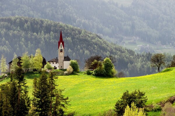 Eine Kapelle, die auf einem Berg inmitten von Löw steht