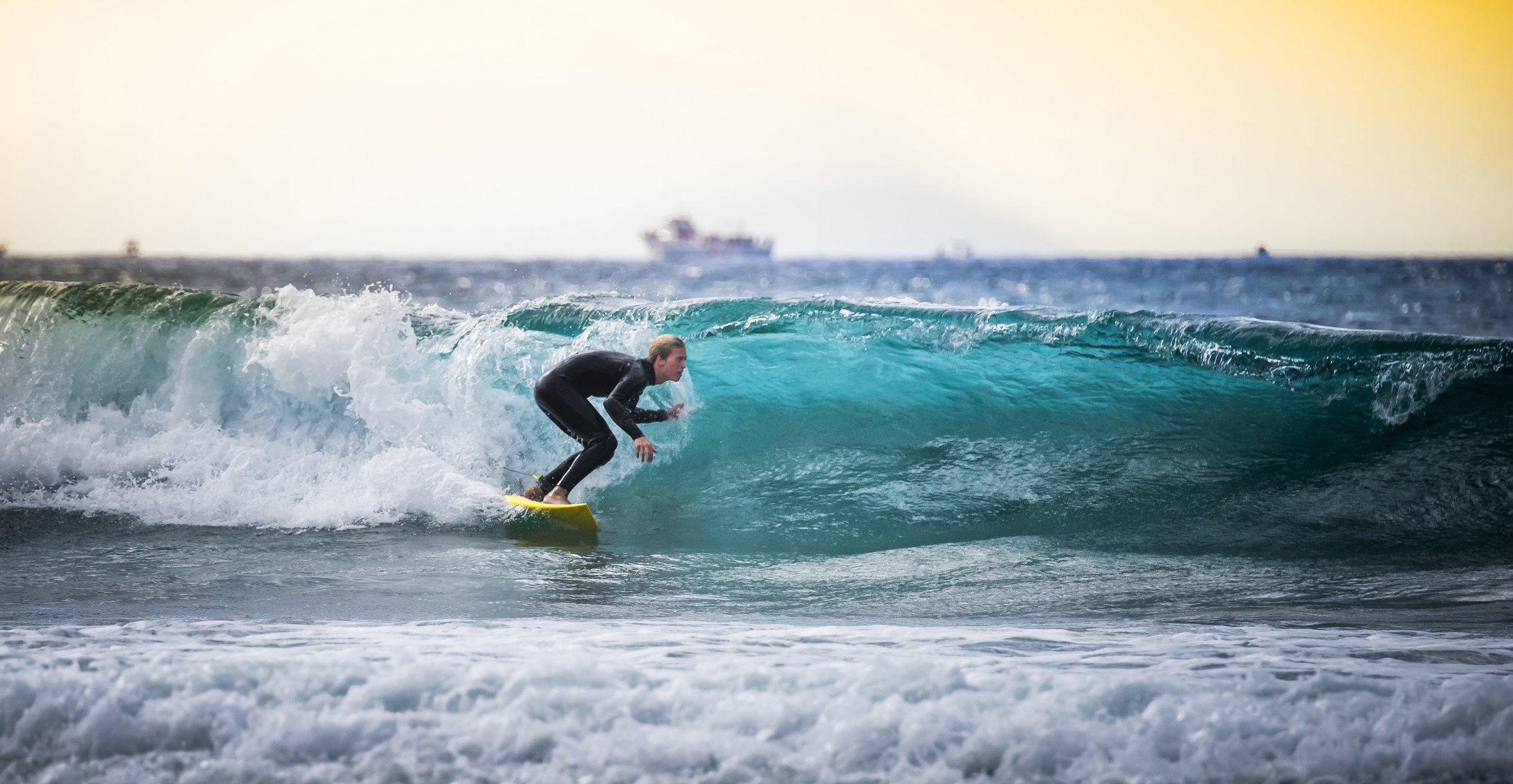 surfer surfing deski surfingowe fale tułów morze statek łodzie horyzont słońce