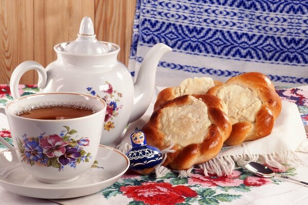 Foto von Tee in einer Teekanne und einem Becher sowie Käsekuchen mit Hüttenkäse