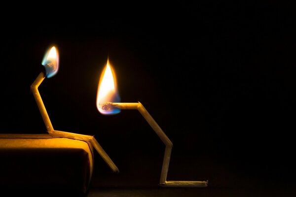 Broken lighted matches on a dark background