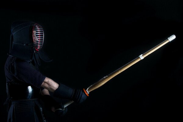 Le combattant de kendo en uniforme noir est prêt pour le combat