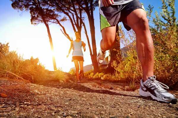 The legs of a runner in sneakers and a girl in a catch-up