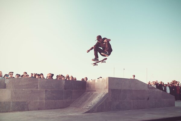 The crowd watches as a skateboarder makes a jump