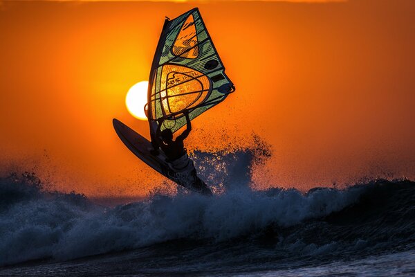 Surf sur les vagues au coucher du soleil dans l océan