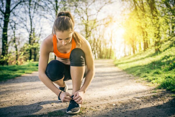 Atado de Zapatillas de deporte de la muchacha atleta