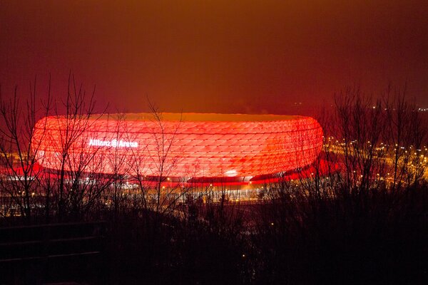 Leuchtendes Stadion in der Nacht. Rote Hintergrundbeleuchtung