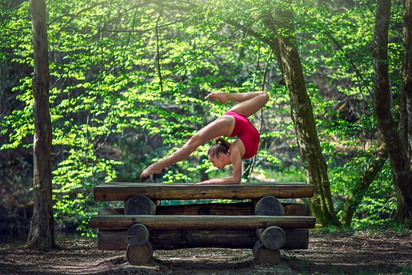 Gymnast in a pose in a dense forest