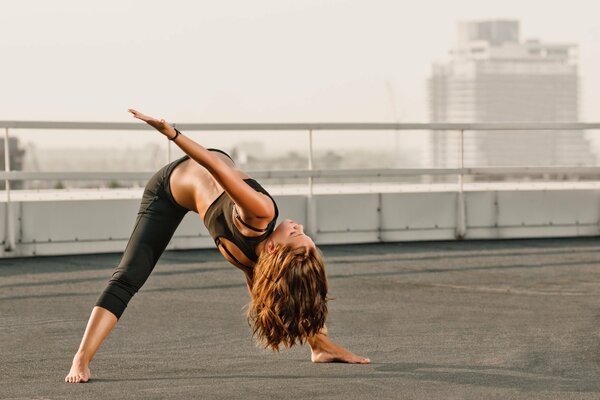 A girl does yoga on the roof