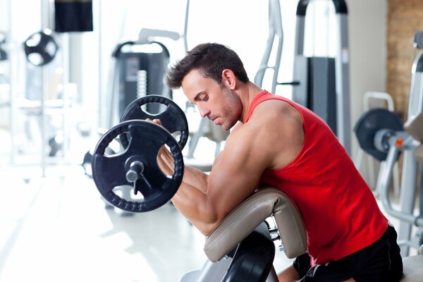 A man exercises his biceps in the gym