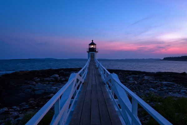Морской пейзаж с пирсом и маяком на закате