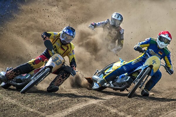 Tres motociclistas en una curva durante una carrera deportiva