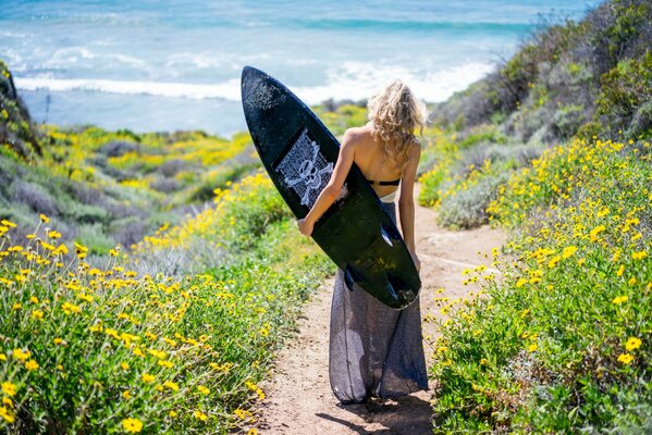 Fille avec un surf sur la plage