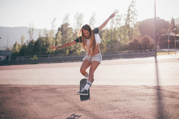 Bella ragazza sportiva su uno skateboard