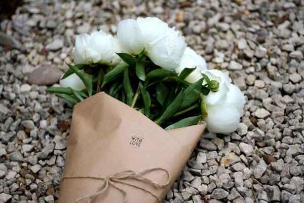 Bouquet of peonies with love on gravel