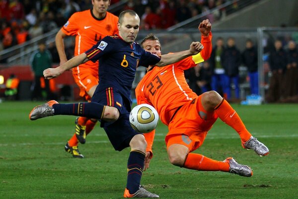 Football players kick the ball during the match